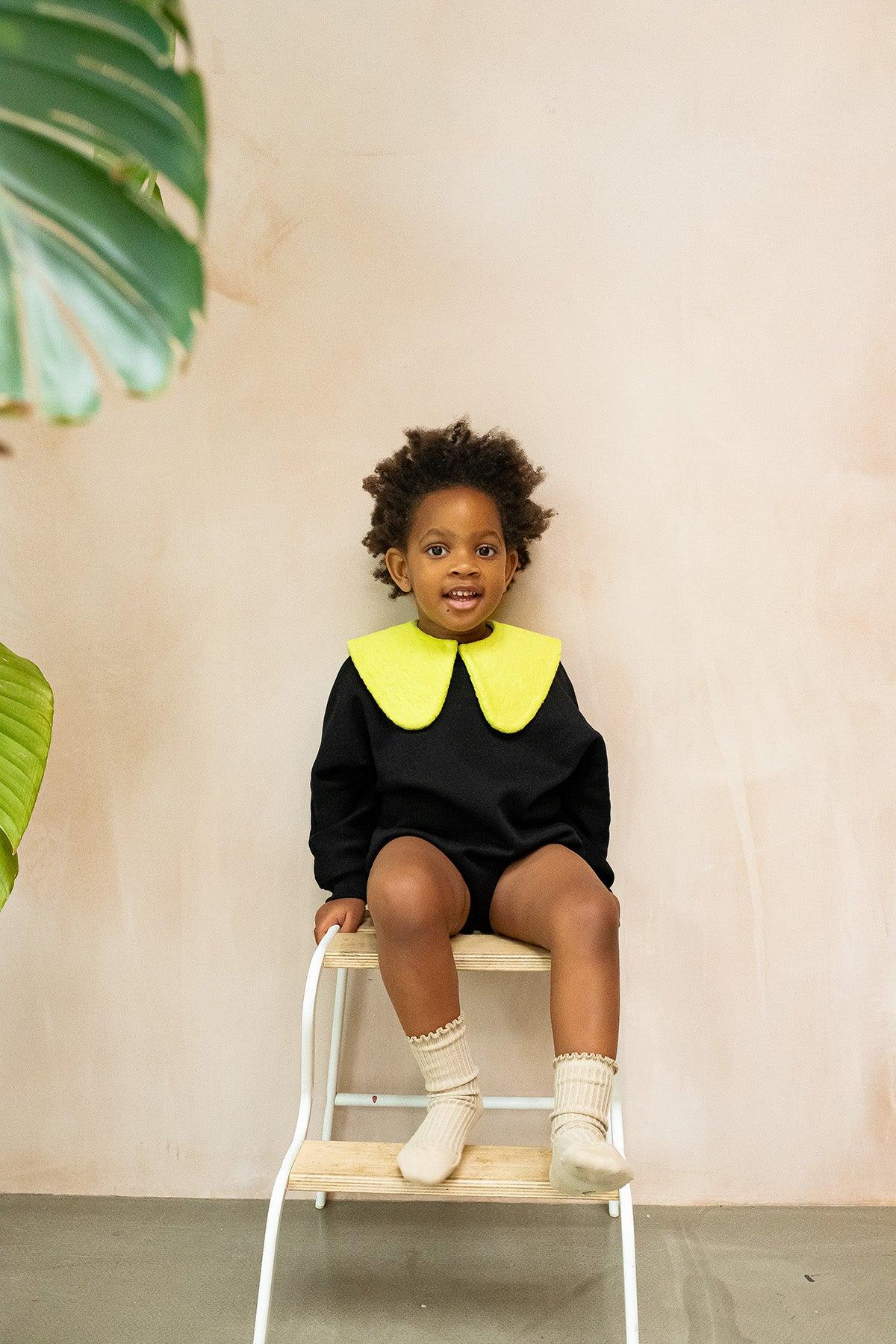 The Atlas Teddy Acid Collar adds a pop of fun to any outfit. Made from soft organic cotton teddy fabric in a bold acid green or soft brown, this collar is perfect for elevating your little one's style. Designed to fit comfortably around the neck with a small button fastening, the Atlas collar adds a playful touch to dresses, sweaters, or even jackets. Its vibrant color and oversized silhouette make it the perfect piece for fashion-forward kids who love to stand out. Key features: Made from 100% organic cotton teddy fabric. Bold acid green or soft brown color for a standout look. Unisex design, making it a versatile accessory for any child. Ideal for gifting or updating your child's wardrobe. Easy to pair with any outfit for an instant style boost. Studio Koter is a modern, unisex, functional kidswear shop designed in the UK and made sustainably in the UK and Portugal.