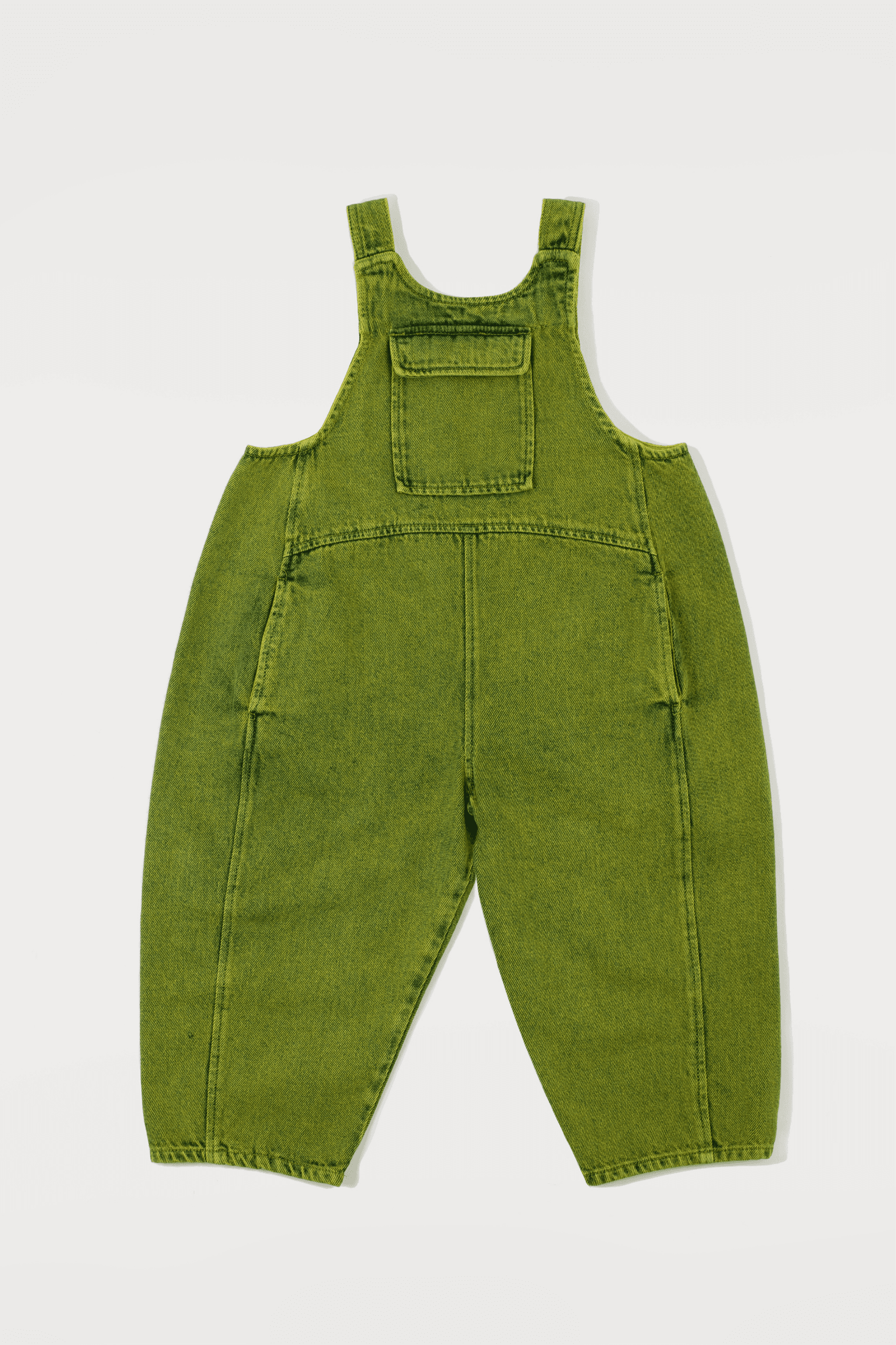 This item is on pre-order and will be ready to ship within 1-2 weeks. Kai is the ultimate go-to for effortless cool, and this season we have reinvented your favourite with a green over-dye. These oversized wide-leg denim dungarees have a relaxed, rounded fit with playful curved seams that bring a new twist to a classic. The front patch pocket adds a utility edge, and additional side seam pockets for all the little treasures. Kai has adjustable strap fastening at the back meaning they grows with your kid, making it a wardrobe staple that can last several years. Crafted from 100% cotton denim - 20% recycled - and produced in Porto, these dungarees are as sustainable as they are stylish. Proudly featured in Sunday Times Style. Studio Koter is a UK-based kidswear shop creating modern pieces for children and toddlers, with each garment produced sustainably in the UK and Portugal.